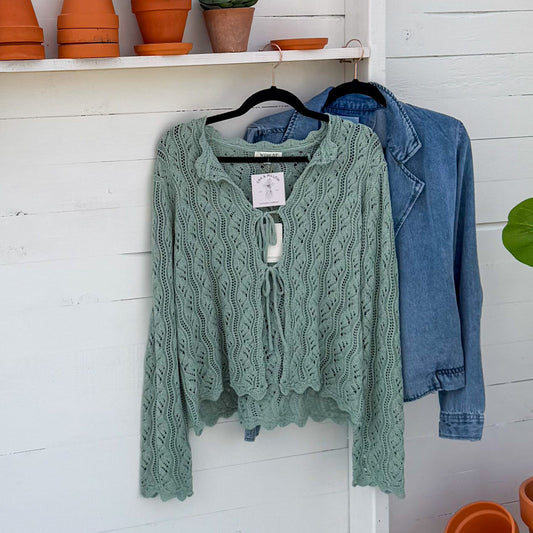 White outdoor shed with clothing and potted plants
